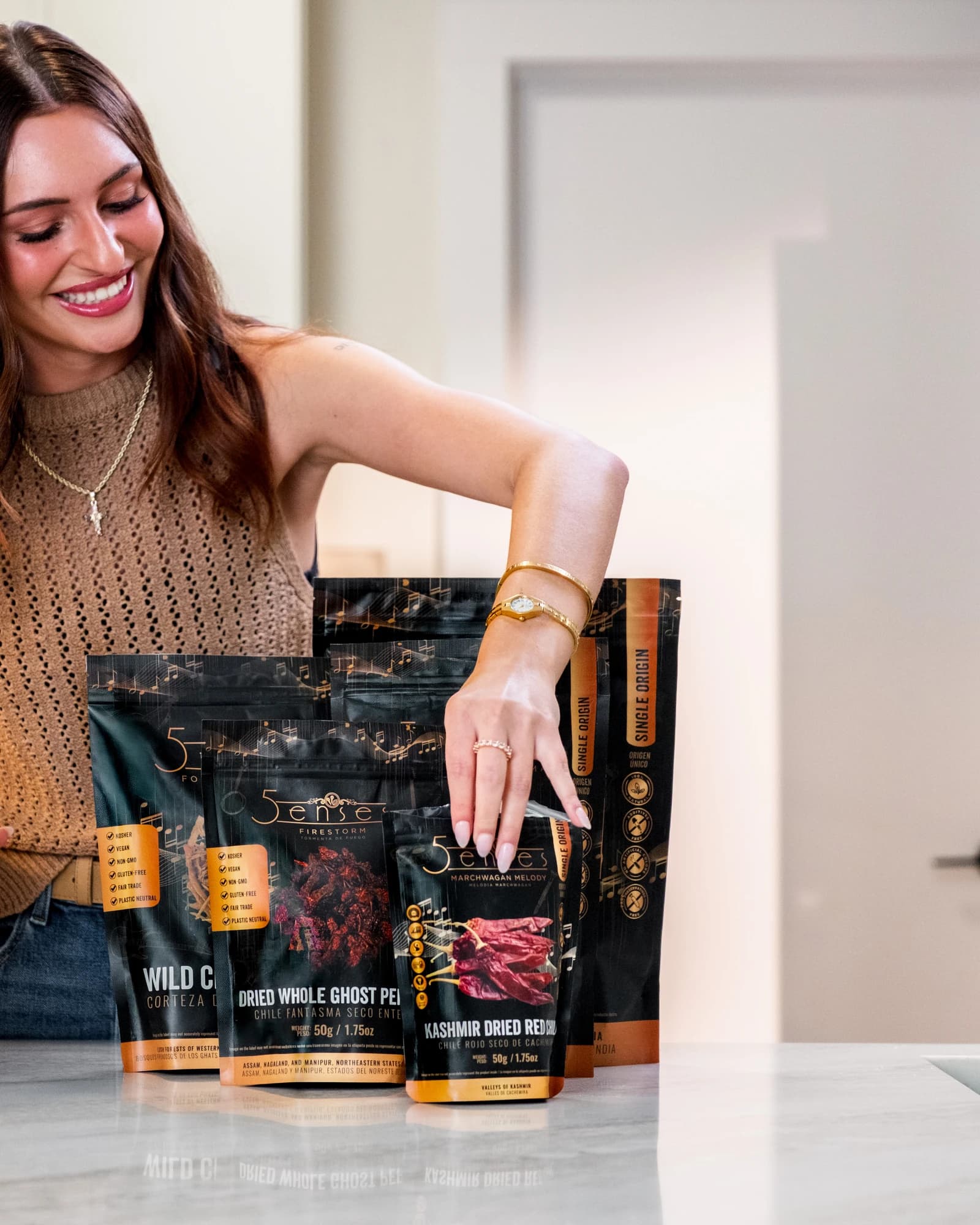 A hand picking a spice pouch from a lineup of options