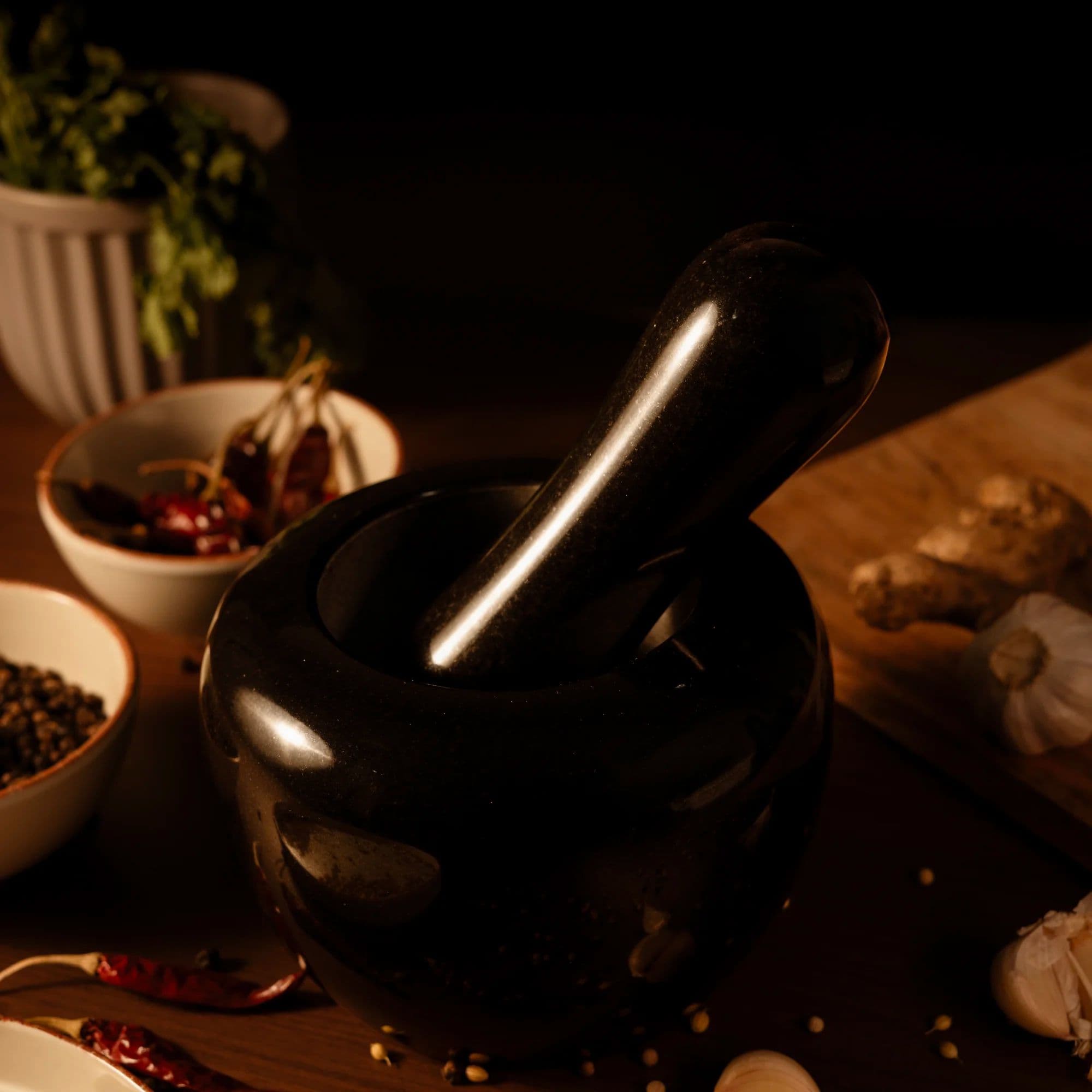 5Senses Adikal black granite mortar and pestle on a wooden countertop with whole spices